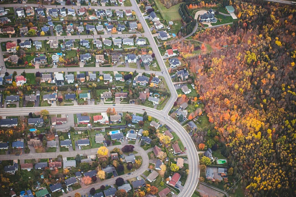 Aerial view of a suburban neighbourhood surrounded by autumn foliage