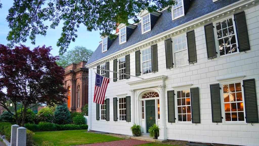 Stately white colonial home with an American flag