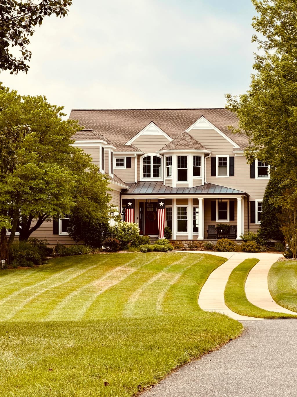 Stately New England colonial home with a manicured lawn on an autumn afternoon