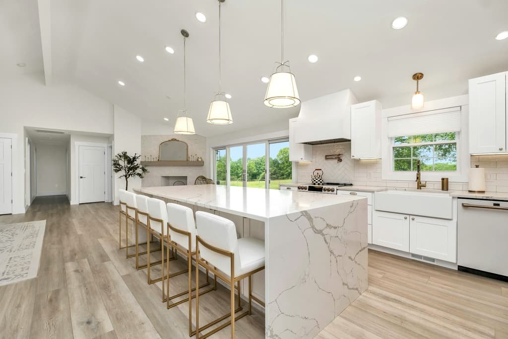 Bright renovated kitchen with a marble island and white cabinetry