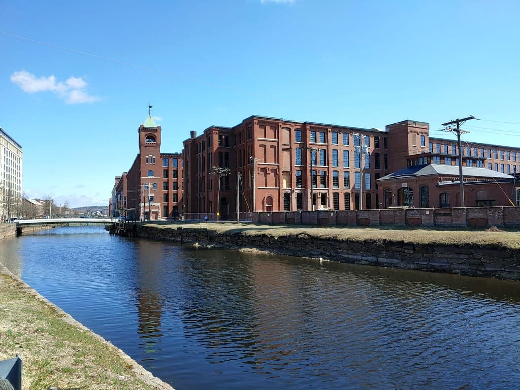 Historic red brick mill buildings along the canal in Lowell, Massachusetts