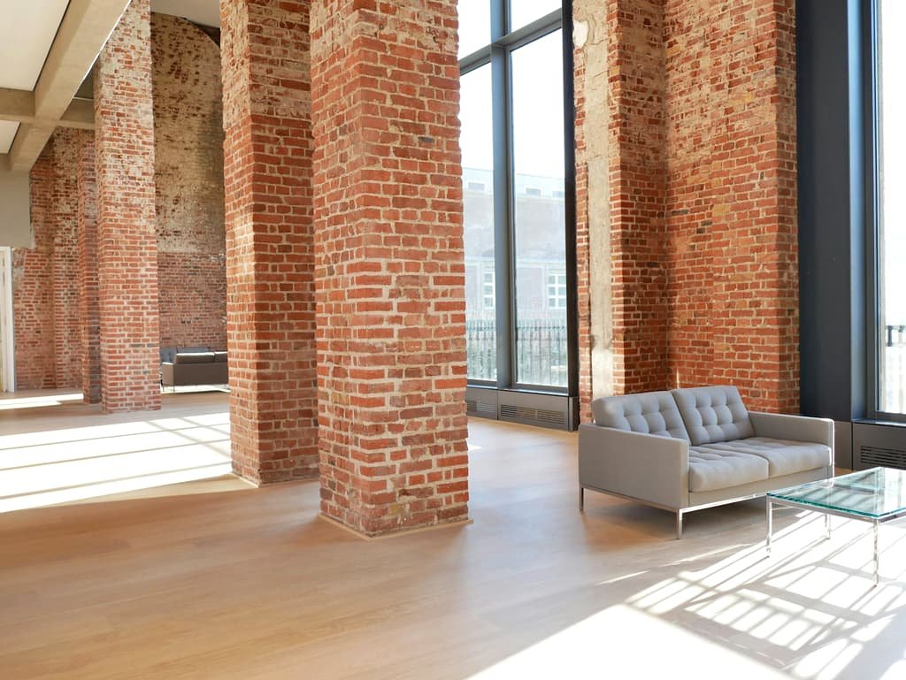 Converted mill loft interior with exposed brick and oversized windows